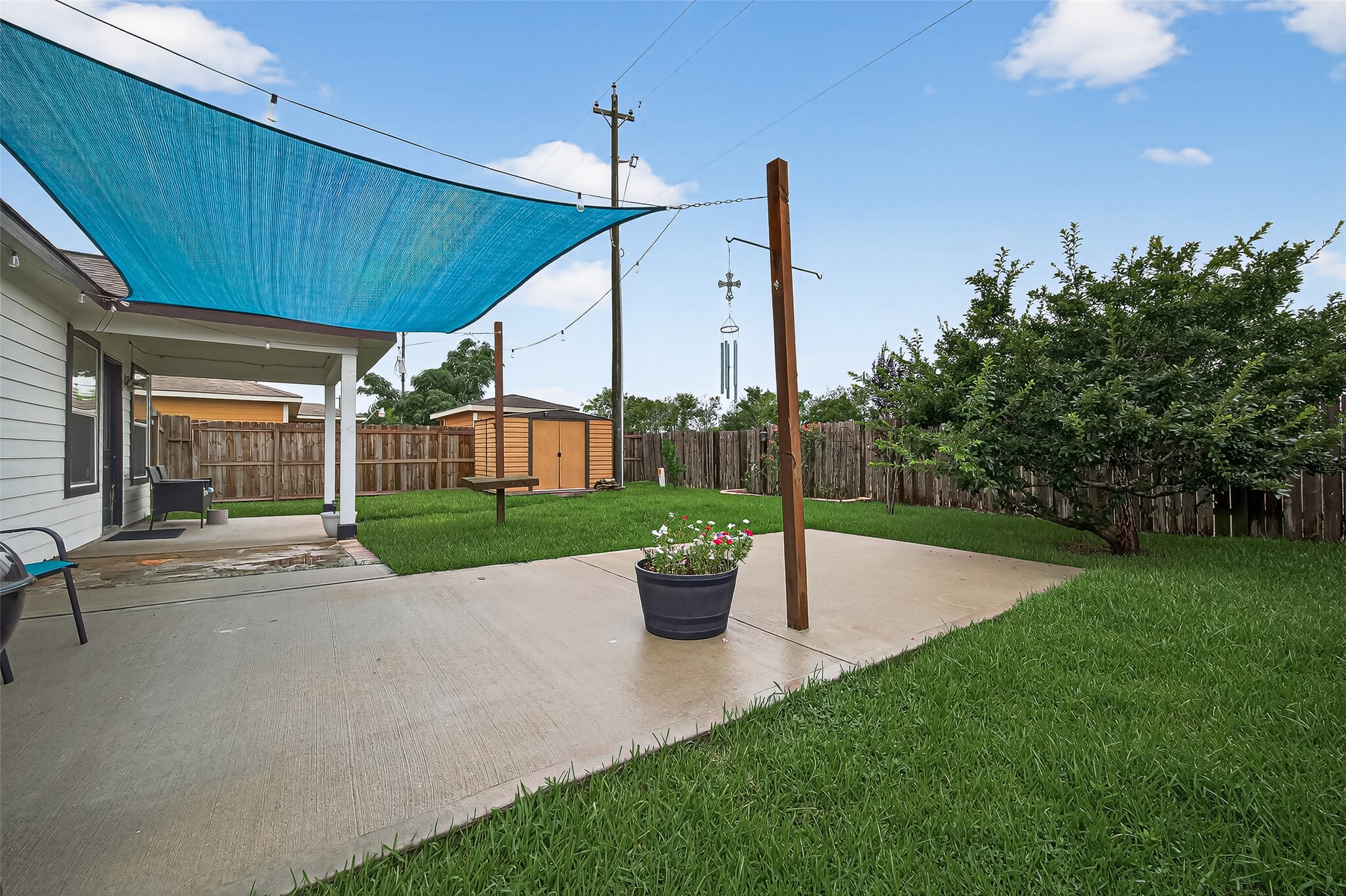 a view of a patio with a table and chairs potted plants with wooden fence