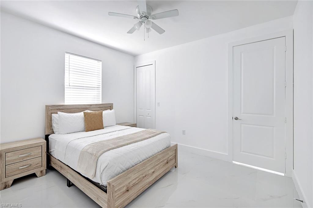 502 Southwest 25th Place Cape Coral, FL 33991 - Photo 15 of 34 a bedroom with a bed and a chandelier