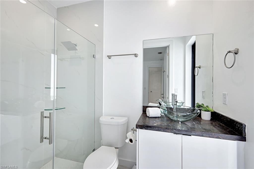 502 Southwest 25th Place Cape Coral, FL 33991 - Photo 16 of 34 a bathroom with a granite countertop sink a toilet and a mirror