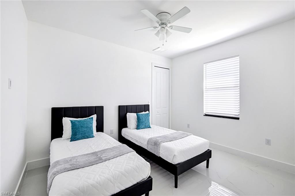 502 Southwest 25th Place Cape Coral, FL 33991 - Photo 17 of 34 a bedroom with a bed and a chandelier