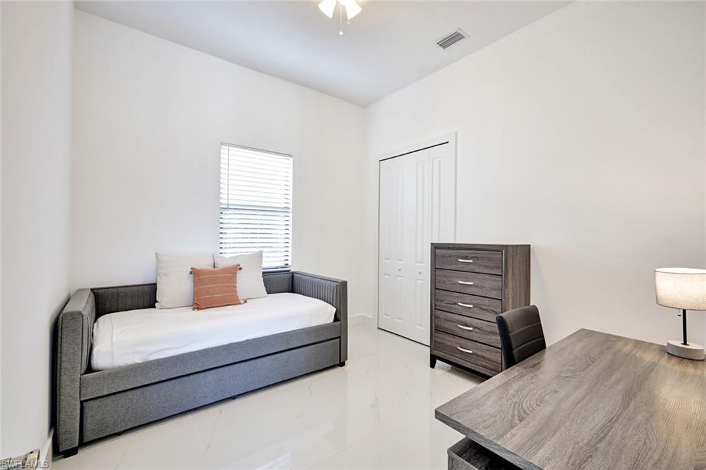 502 Southwest 25th Place Cape Coral, FL 33991 - Photo 19 of 34 a bedroom with a bed and dresser