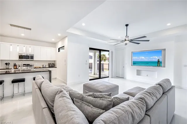 a kitchen with stainless steel appliances granite countertop a sink a stove a refrigerator cabinets and chairs