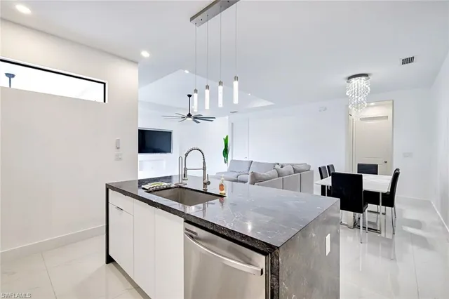 a kitchen with granite countertop a sink and white cabinets