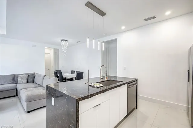 a living room with furniture a chandelier and a window