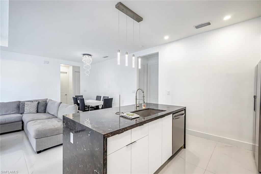 502 Southwest 25th Place Cape Coral, FL 33991 - Photo 27 of 34 a kitchen with granite countertop a sink and white cabinets