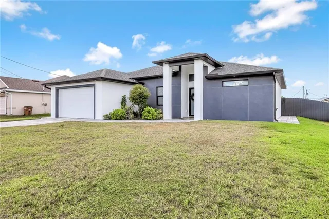 a view of a house with a yard and garage