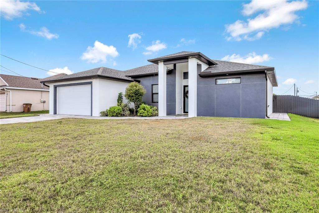 502 Southwest 25th Place Cape Coral, FL 33991 - Photo 3 of 34 a view of a house with a yard and garage