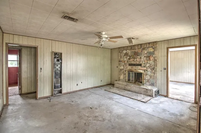 a view of an empty room with a fireplace and a window