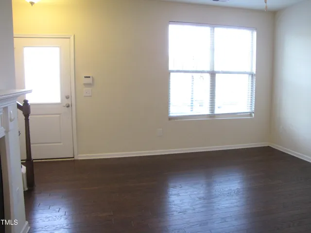 an empty room with wooden floor and a window