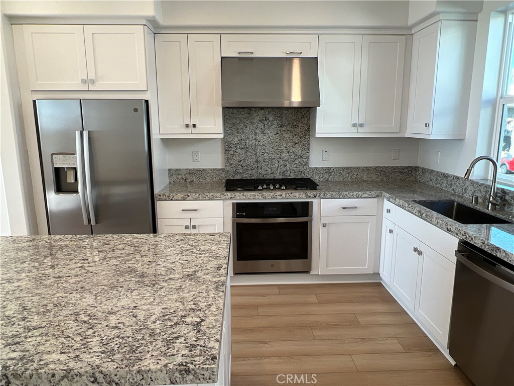468 Palermo Lake Forest, CA 92630 - Photo 3 of 22 a kitchen with granite countertop white cabinets and stainless steel appliances