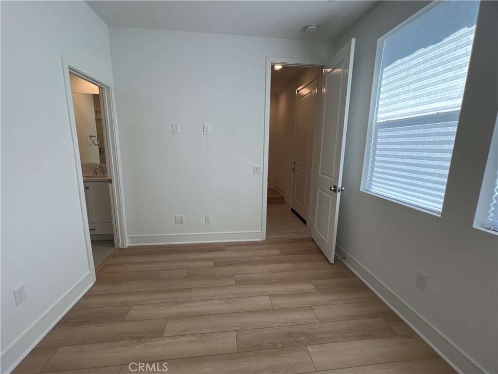 468 Palermo Lake Forest, CA 92630 - Photo 9 of 22 a view of a hallway with wooden floor and a bathroom