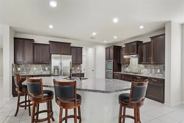 a living room with furniture kitchen view and a chandelier