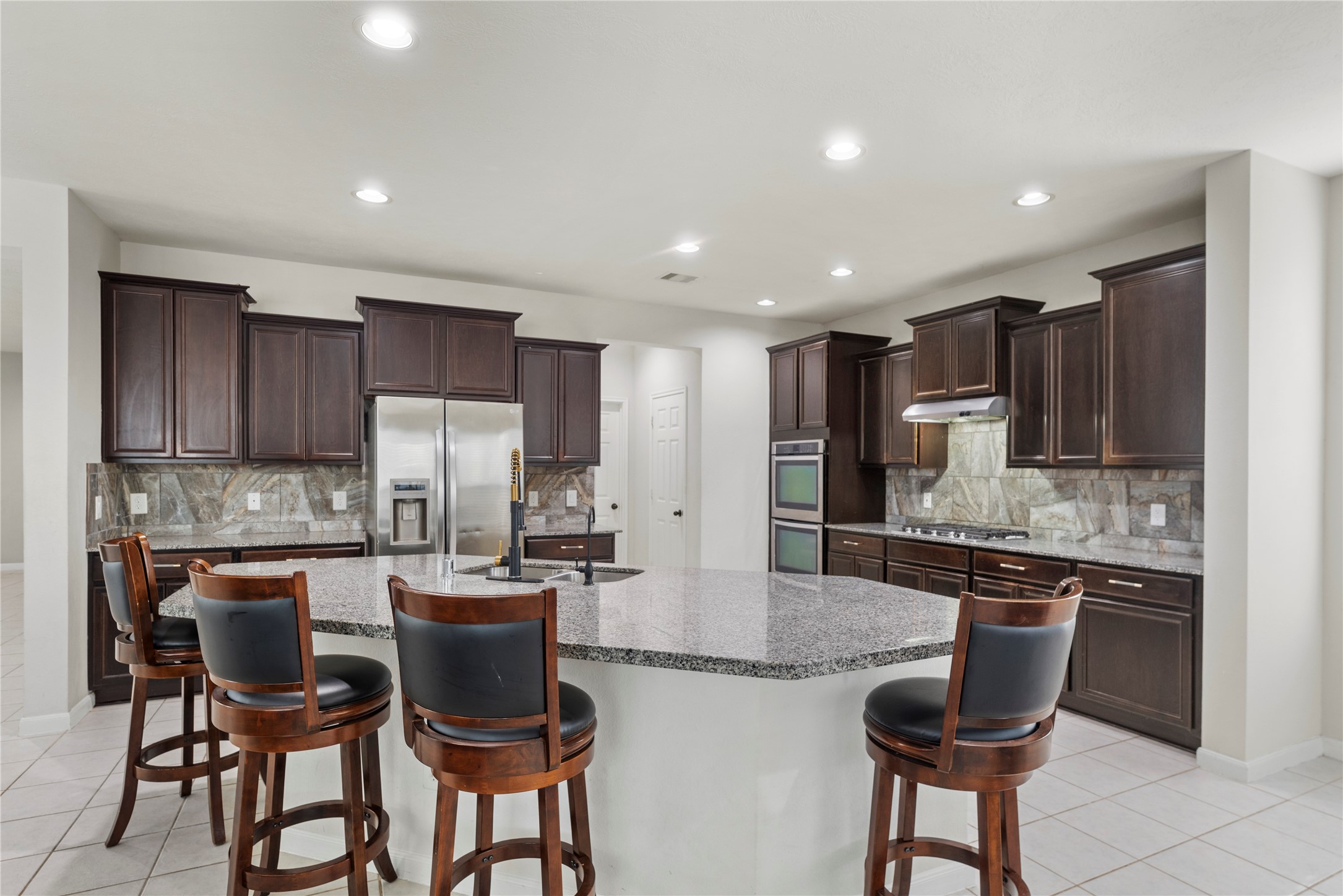 4103 Sherry Mist Lane Katy, TX 77449 - Photo 5 of 19 Step into a kitchen designed for convenience and enjoyment, complete with granite countertops, recessed lighting and a large island with breakfast bar seating that serves as a focal point.
