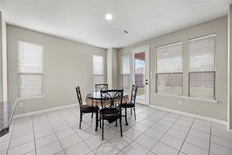 a kitchen with refrigerator and chairs