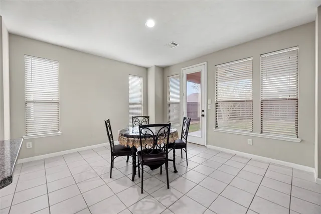 a kitchen with refrigerator and chairs