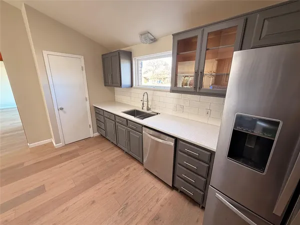 a kitchen with stainless steel appliances granite countertop a refrigerator and a sink