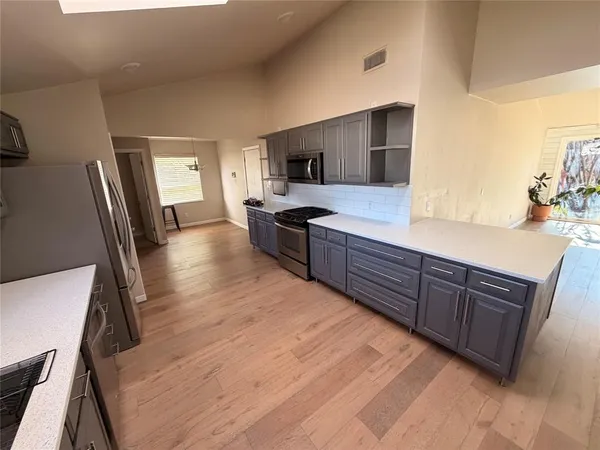 a kitchen with stainless steel appliances granite countertop a sink dishwasher stove and refrigerator