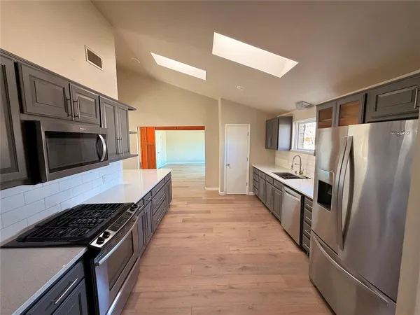 a kitchen with stainless steel appliances a refrigerator and a stove top oven