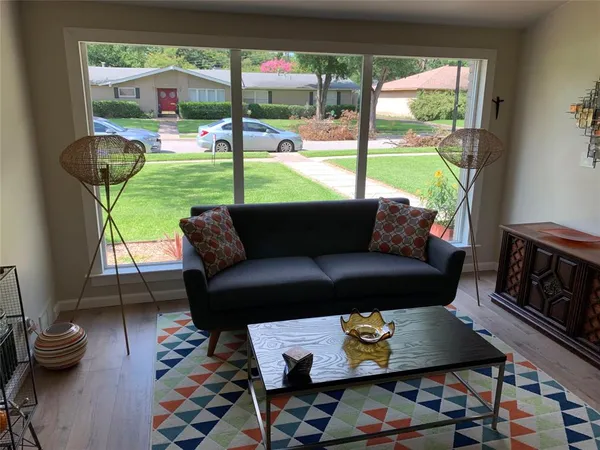 a living room with furniture and a floor to ceiling window