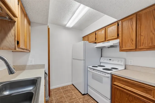 a kitchen with stainless steel appliances white cabinets and a stove top oven