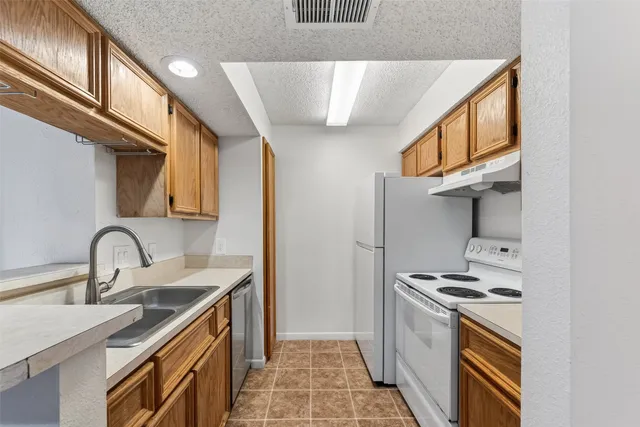 a kitchen with stainless steel appliances a sink a stove and a refrigerator