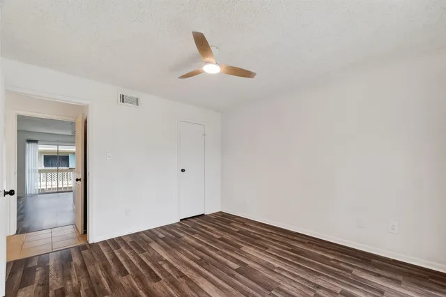 a view of empty room with wooden floor