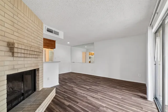 a view of a livingroom with wooden floor and a fireplace
