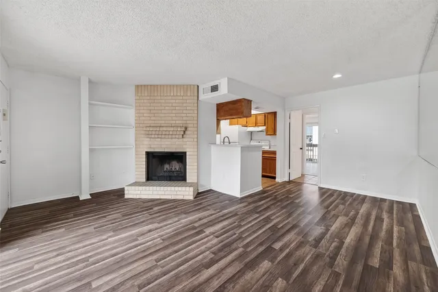 a view of a livingroom with wooden floor and a fireplace