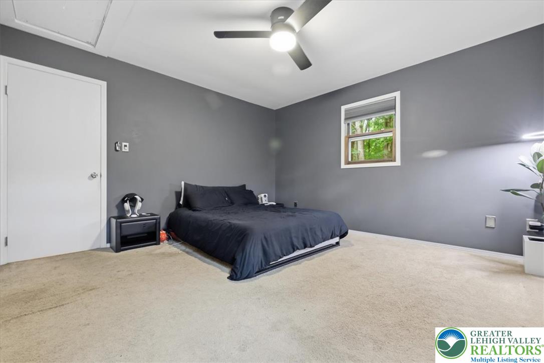 520 Highland Hill Road Jim Thorpe, PA 18235 - Photo 26 of 83 A well-lit bedroom features plush carpeting and a modern ceiling fan, offering comfortable repose.
