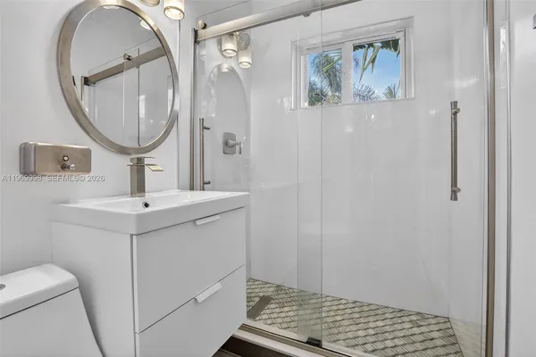 a bathroom with a sink mirror and toilet