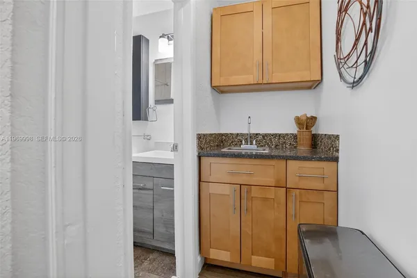 a kitchen with granite countertop white cabinets and stainless steel appliances