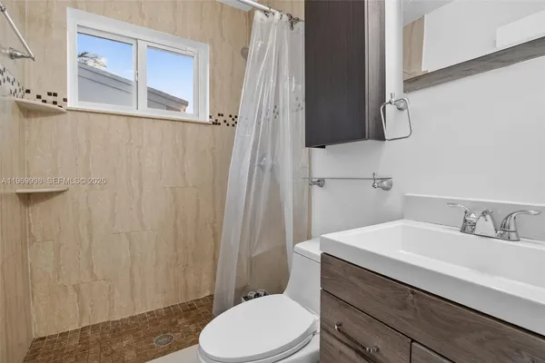 a bathroom with a sink a toilet and shower curtain