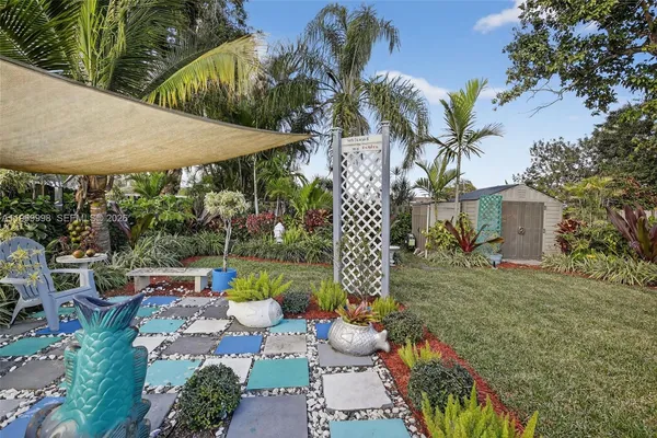 a backyard of a house with table and chairs potted plants