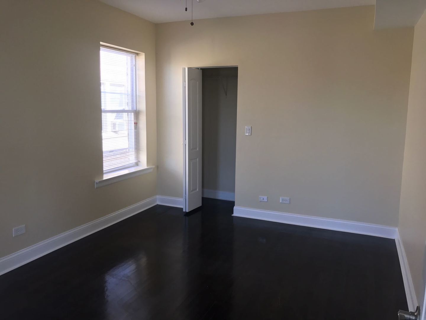 Undisclosed Address Chicago, IL 60625 - Photo 3 of 11 an empty room with wooden floor and windows
