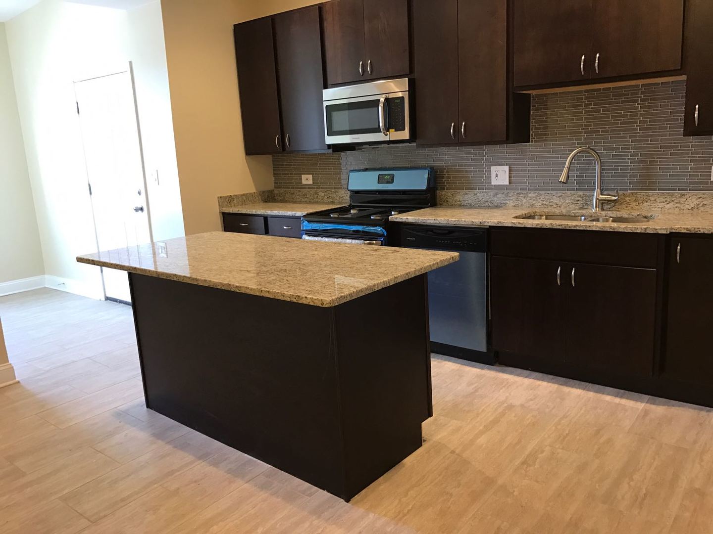 Undisclosed Address Chicago, IL 60625 - Photo 6 of 11 a kitchen with stainless steel appliances a sink dishwasher a stove and a microwave oven
