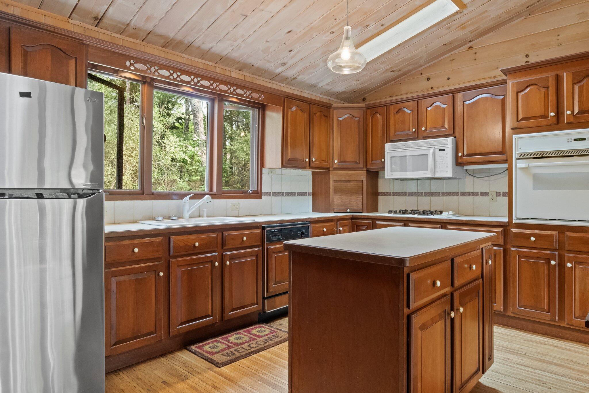 346 Setucket Road Dennis, MA 02638 - Photo 37 of 41 a kitchen with stainless steel appliances granite countertop a refrigerator a sink dishwasher a stove and white countertops with wooden floor