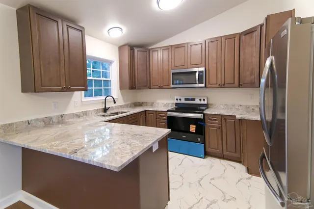a kitchen with granite countertop stainless steel appliances and wooden cabinets
