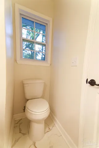 a white toilet sitting next to a window