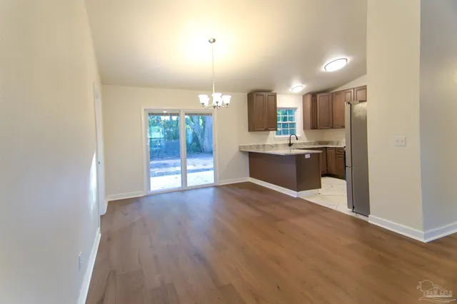 a view of kitchen with granite countertop cabinets and refrigerator