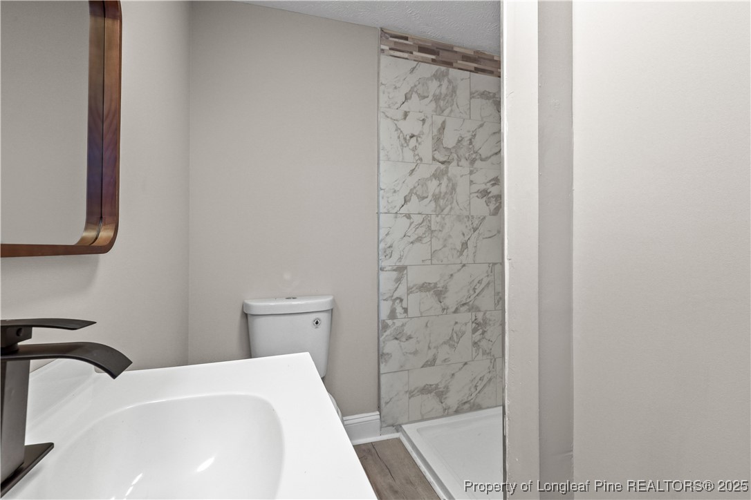 2302 Odom Road Hope Mills, NC 28348 - Photo 14 of 33 a bathroom with a sink a toilet and shower