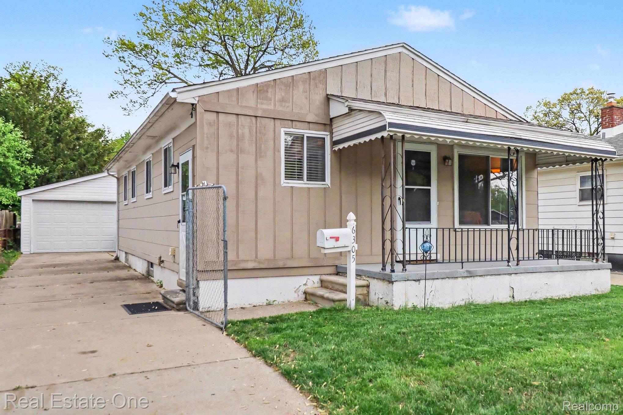 6305 Beech Daly Road Taylor, MI 48180 - Photo 3 of 22 Bungalow-style house with covered porch, a garage, board and batten siding, and an outbuilding