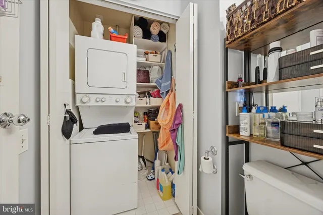 a kitchen view of a kitchen island with stainless steel appliances granite countertop lots of clutter