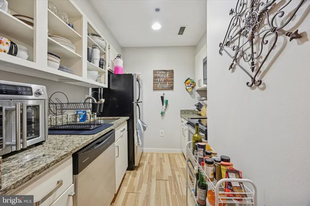 a kitchen with stainless steel appliances granite countertop a refrigerator and a stove top oven