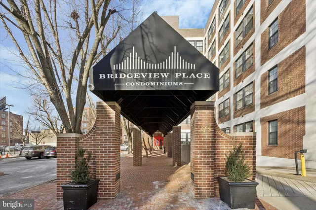 a view of a brick house with a large tree