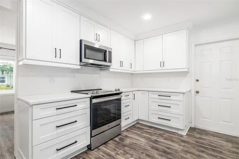 a kitchen with stainless steel appliances white cabinets and a stove a oven with white countertops