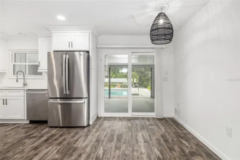 a kitchen with kitchen island wooden floor and a refrigerator
