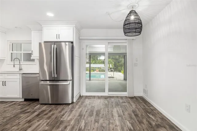a kitchen with kitchen island wooden floor and a refrigerator