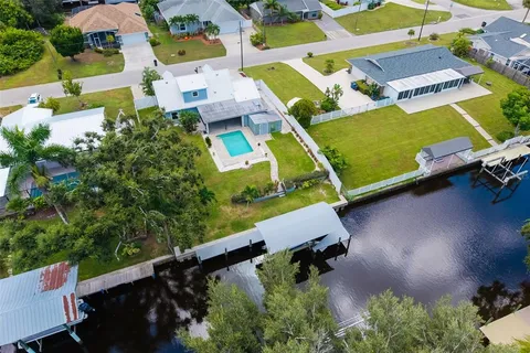 an aerial view of a house with a yard and lake view