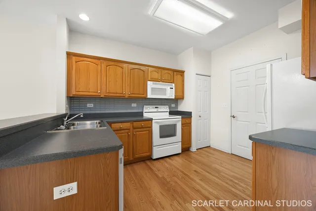 a kitchen with granite countertop a sink cabinets and stainless steel appliances
