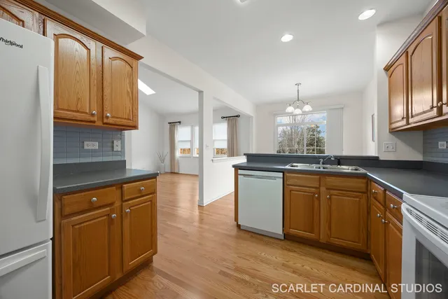 a kitchen with granite countertop a sink cabinets and wooden floor